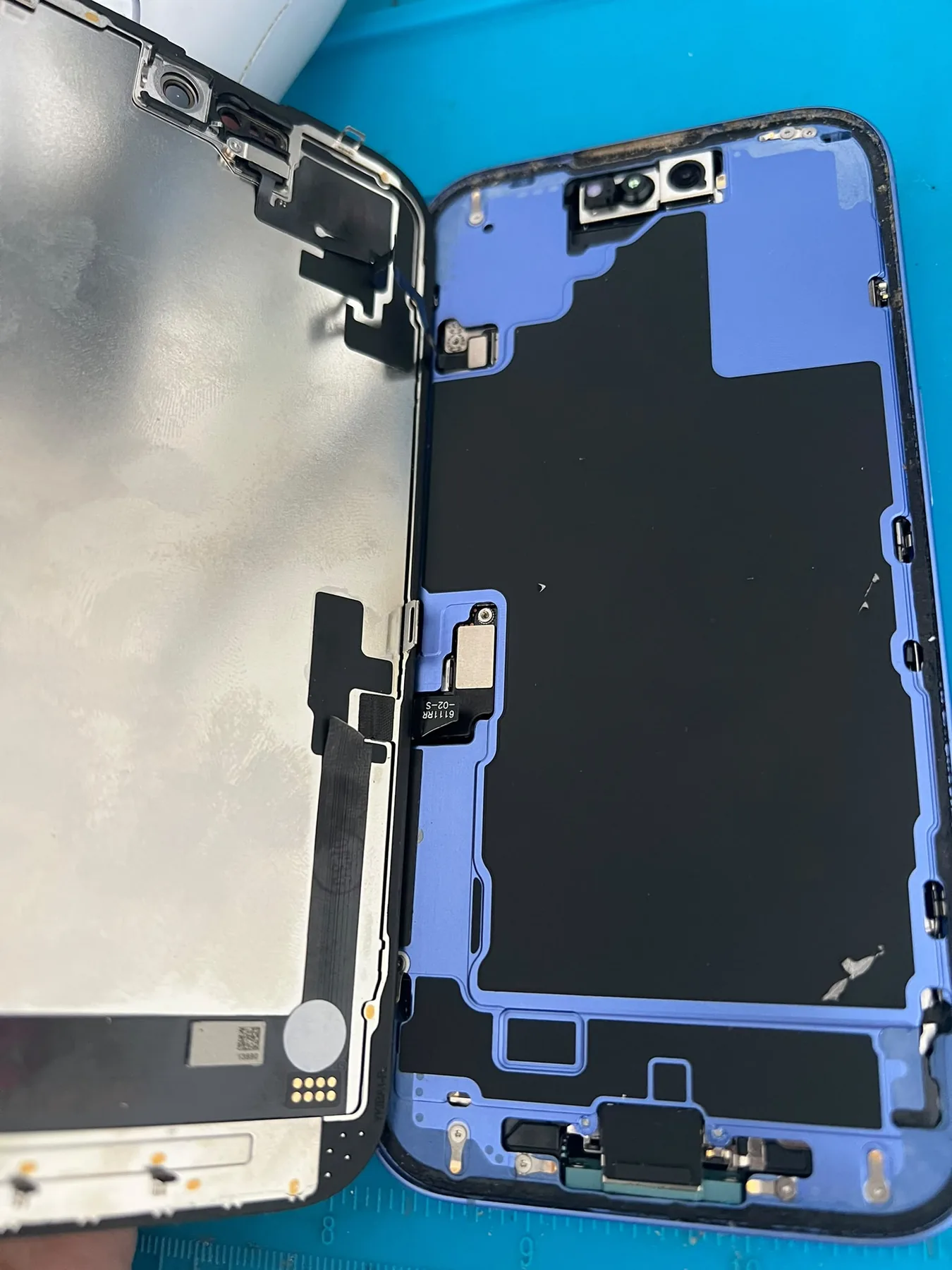 Photo réelle d’un iPhone ouvert pendant une intervention sur l’écran chez Badiphone à Lille.