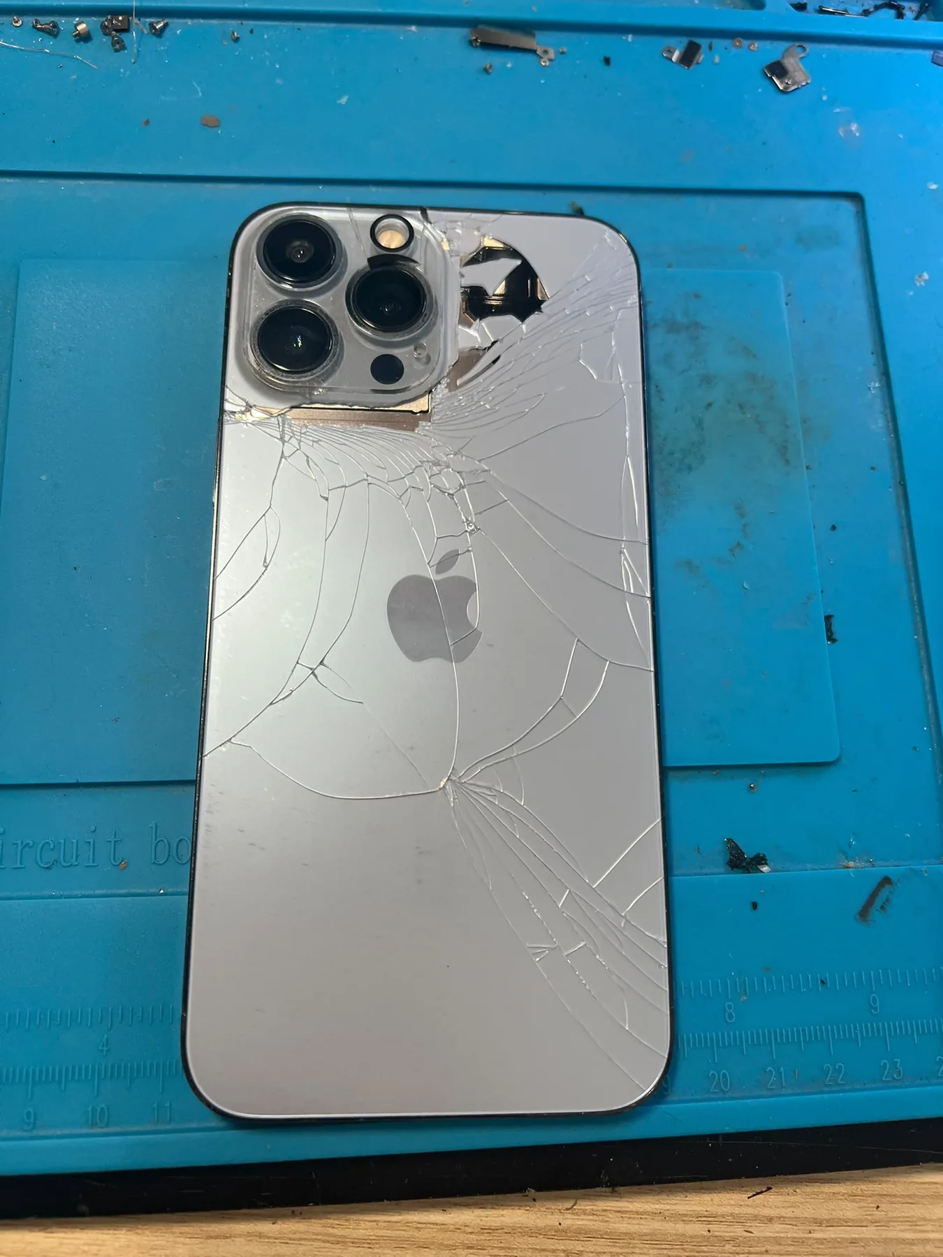 Photo réelle d’un iPhone avec vitre arrière endommagée avant réparation chez Badiphone à Lille.